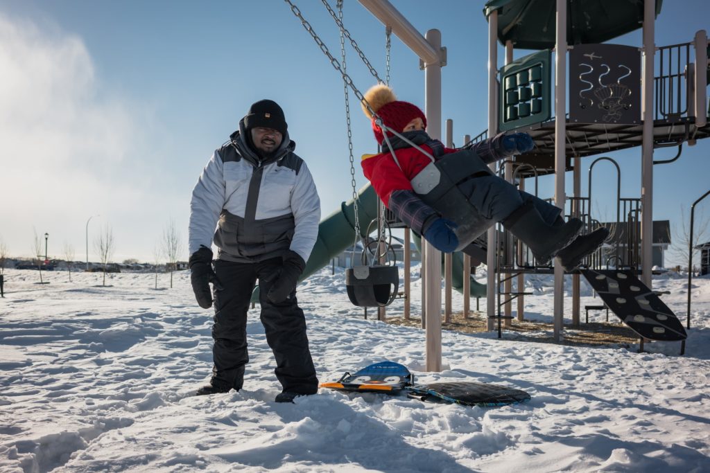 a father pushing his son on a swing at the North Point playground